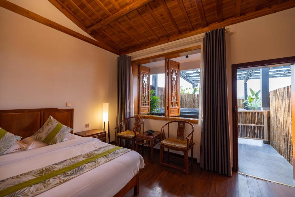 a bedroom with a bed and a large window at 青城山泉青小院温泉中式民宿 in Taiping