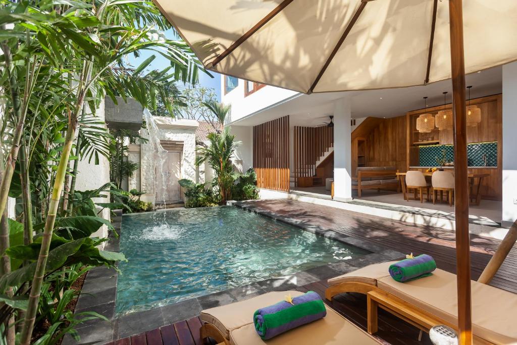 an indoor pool in a house with plants at The Arca Villas by GenuineHost in Sanur