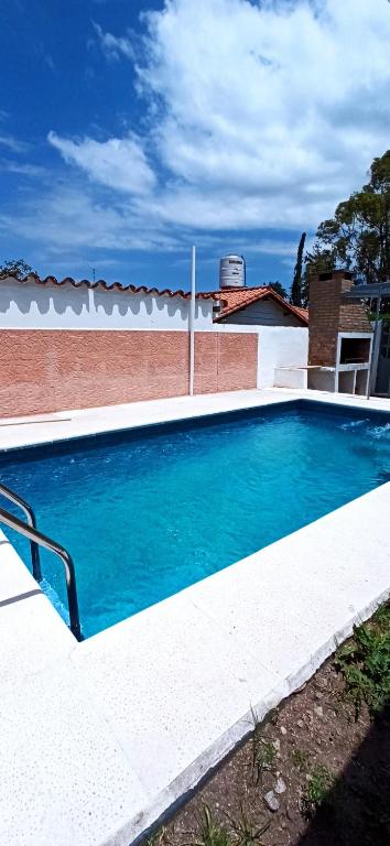 a large blue swimming pool in front of a building at Sierras in La Falda