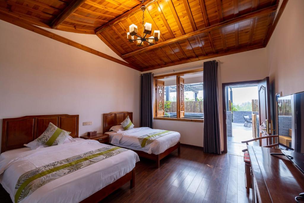 a bedroom with two beds and a large window at 青城山泉青小院温泉中式民宿 in Taiping