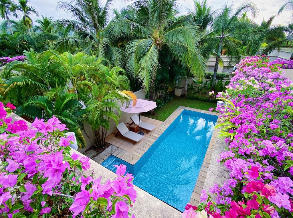 un jardín con piscina y flores púrpuras en Perfect 2br Pool Villa In Residence Bangtao Beach4, en Bang Tao Beach