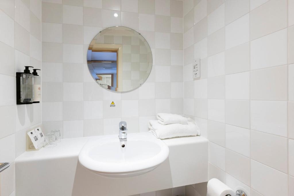 a white bathroom with a sink and a mirror at Holiday Inn - Glasgow Airport by IHG in Paisley