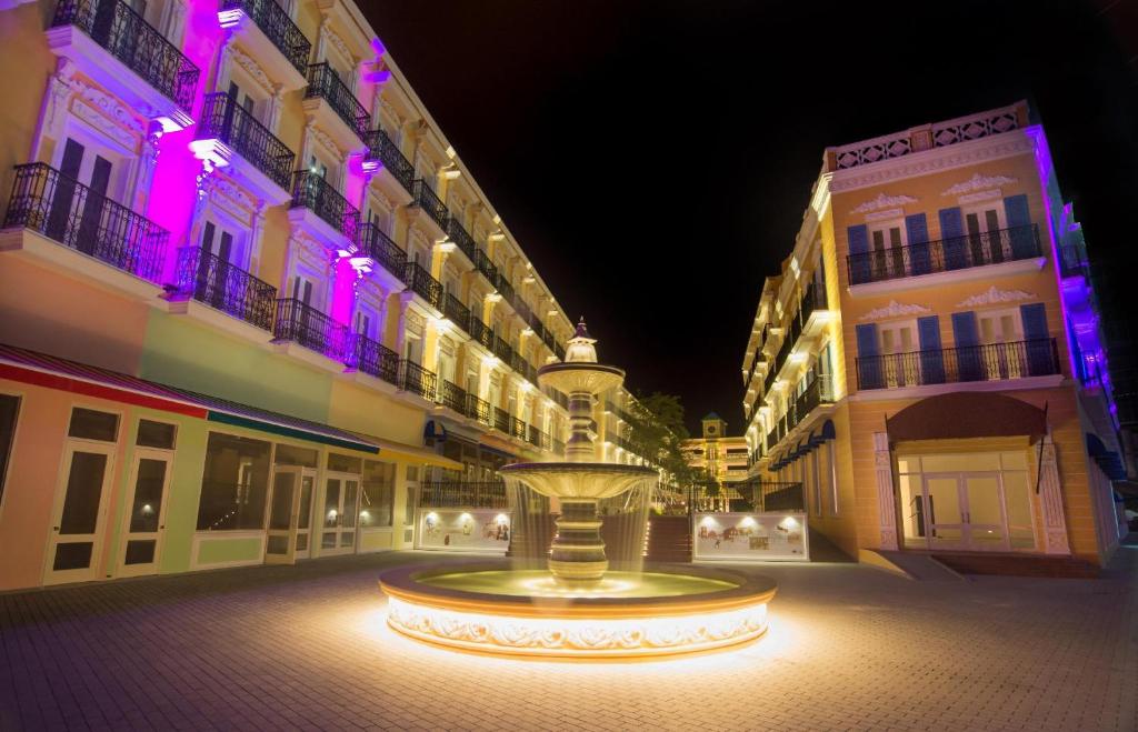 a fountain in the middle of a street at night at Riviera Suites Melaka in Melaka