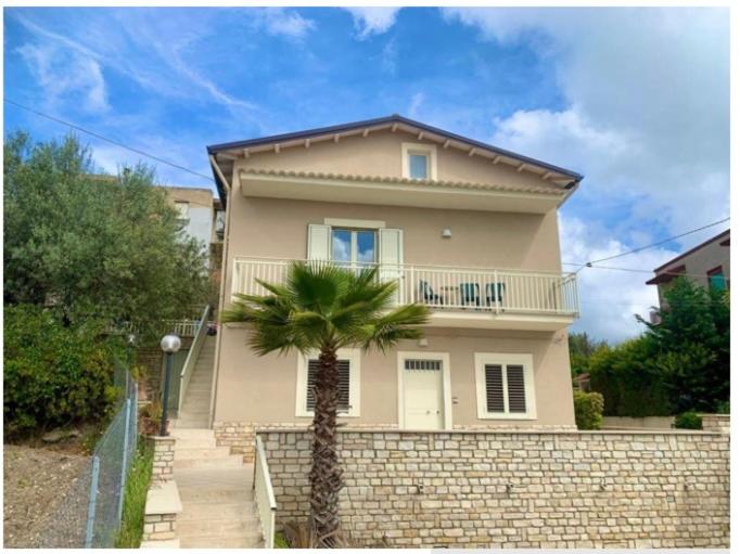 a house with a palm tree in front of it at Villa Annunziata Superior in Aragona
