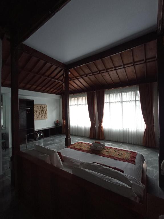 Postel nebo postele na pokoji v ubytování Kampoeng Joglo Abangan Ubud