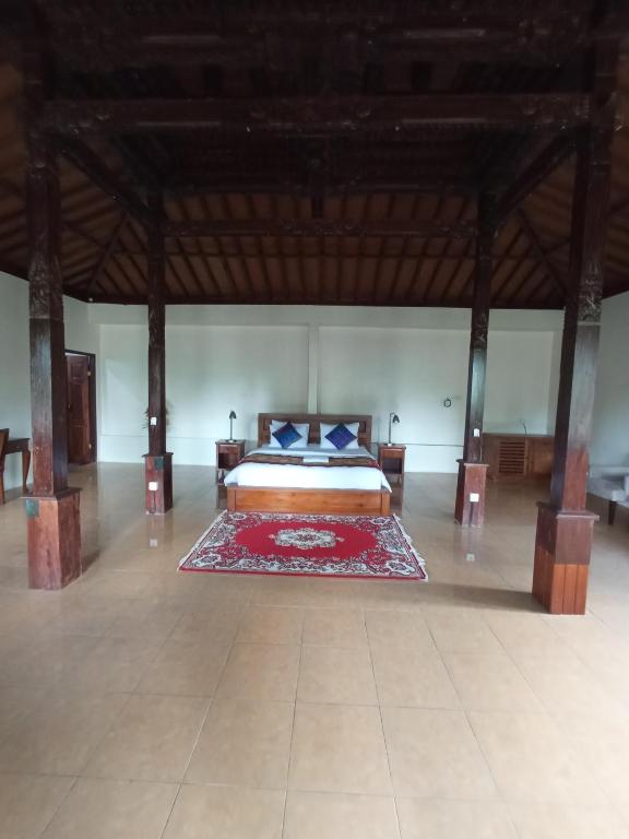 Postel nebo postele na pokoji v ubytování Kampoeng Joglo Abangan Ubud