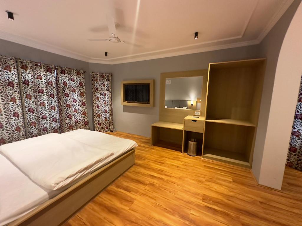 a bedroom with a white bed and a bathroom at Silk Route in Srinagar