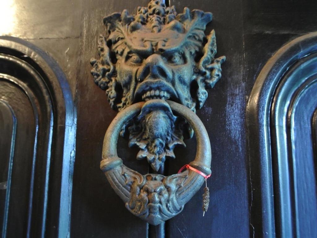 a metal door knocker with a skull on it at The Covenstead in Glastonbury