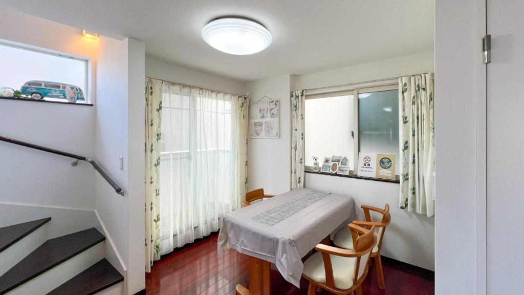 ein Raum mit einem Tisch und Stühlen und einem Fenster in der Unterkunft JING HOUSE Shintakasago - Vacation STAY 17117 in Tokio