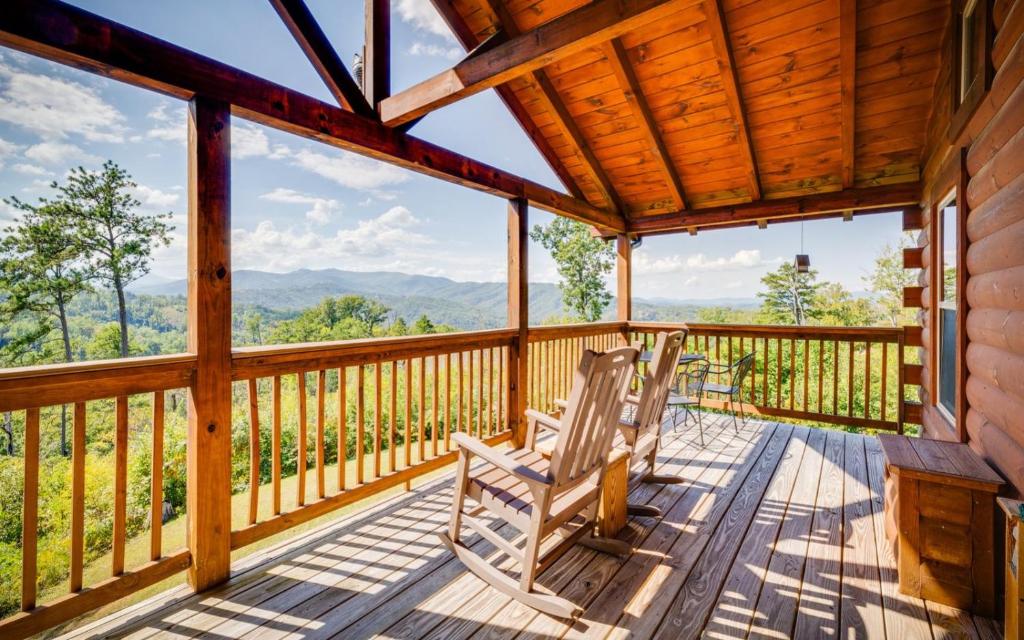 two chairs sitting on a deck with a view of the mountains at Ever After Gatlinburg in Gatlinburg