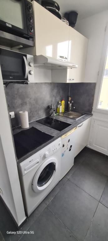 una cocina con lavadora y fregadero en Studio Colombes fonctionnel, en Colombes
