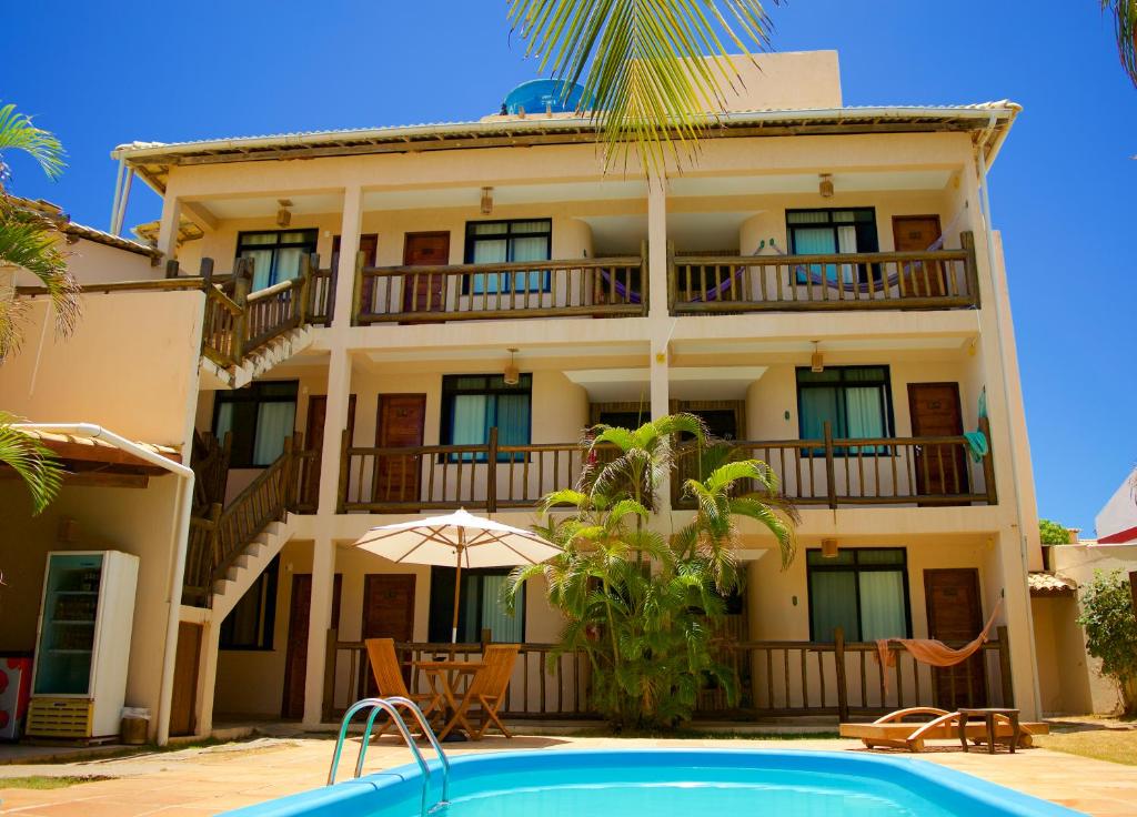 um hotel com piscina em frente a um edifício em Pousada Stella Tropical em Salvador