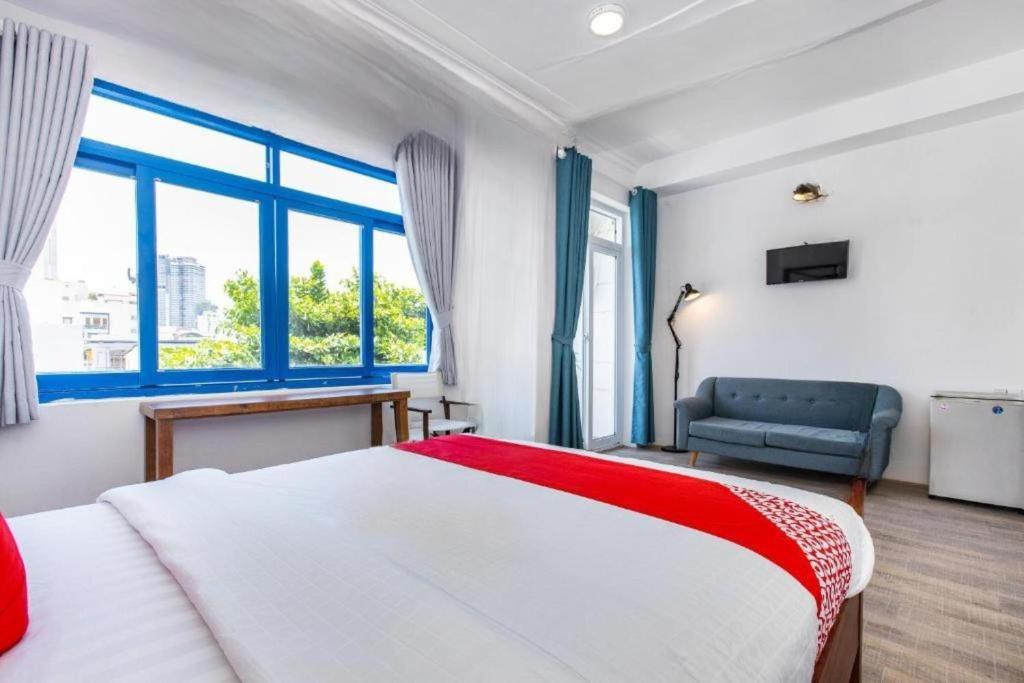 una camera da letto con un letto, un divano e finestre di GIS Hotel Nha Trang & Motorbike Rental a Nha Trang