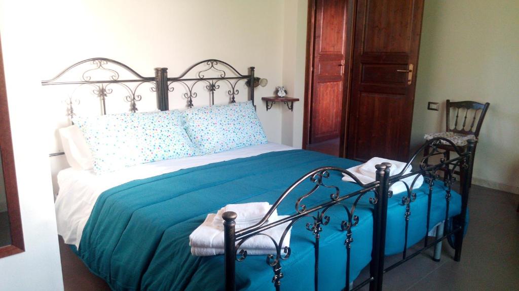 a bedroom with a bed with a blue comforter at Affittacamere Carpe Diem in Gonnosfanàdiga