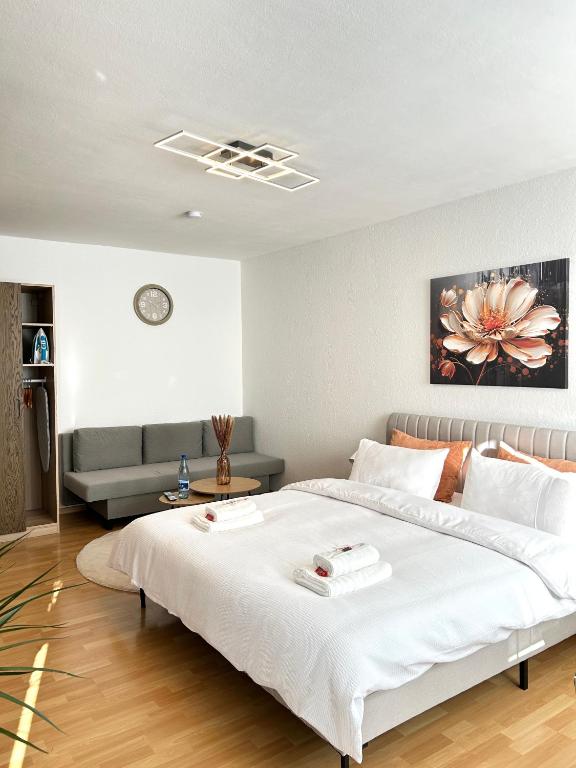 a bedroom with a large white bed and a couch at Wohnung in Monheim am Rhein in Monheim