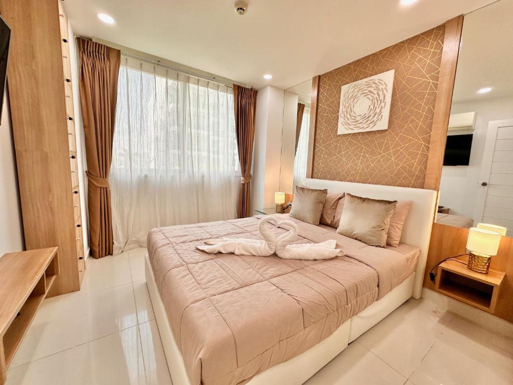 a bedroom with a bed with a towel on it at PALMTREE BREEZE Condo in Amazon Residence in Jomtien Beach