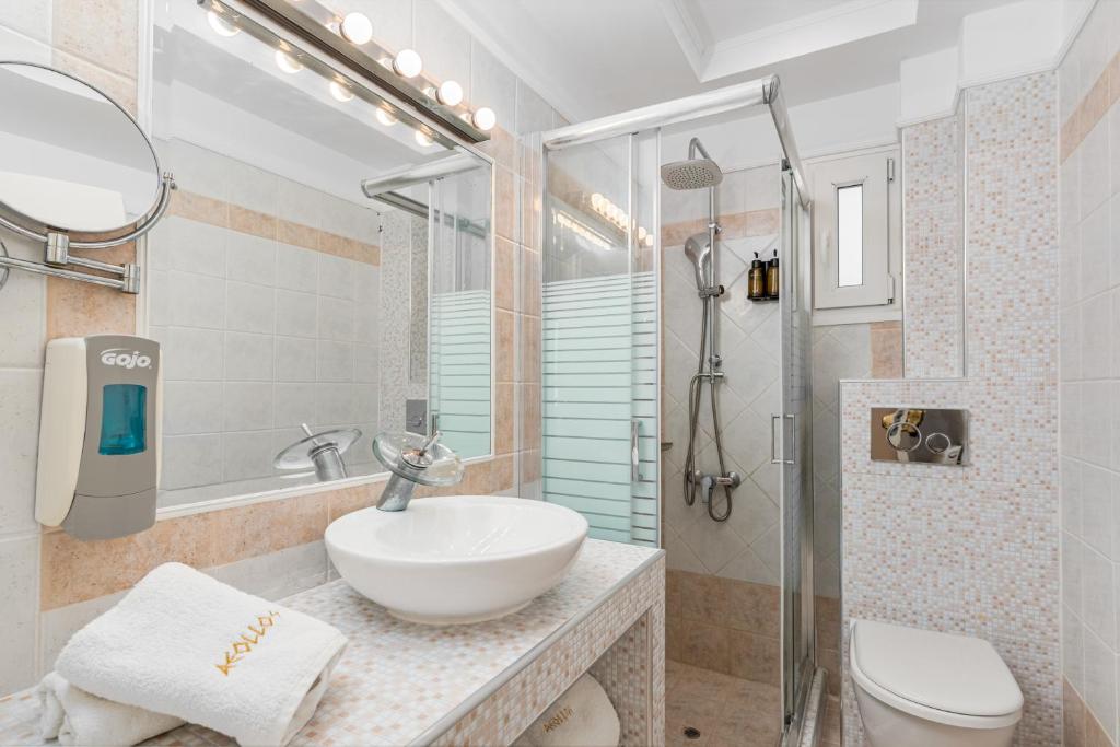 a bathroom with a sink and a shower and a toilet at Hotel Aeollos in Pefkochori