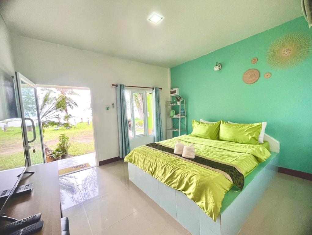 ein Schlafzimmer mit einem Bett und einer grünen Wand in der Unterkunft Ava Beach Pakbara in Ban Pak Ba Ra