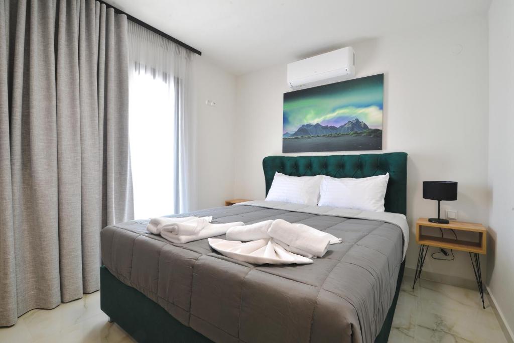 a bedroom with a bed with white towels on it at Anemos Luxury Apartments in Leptokaria