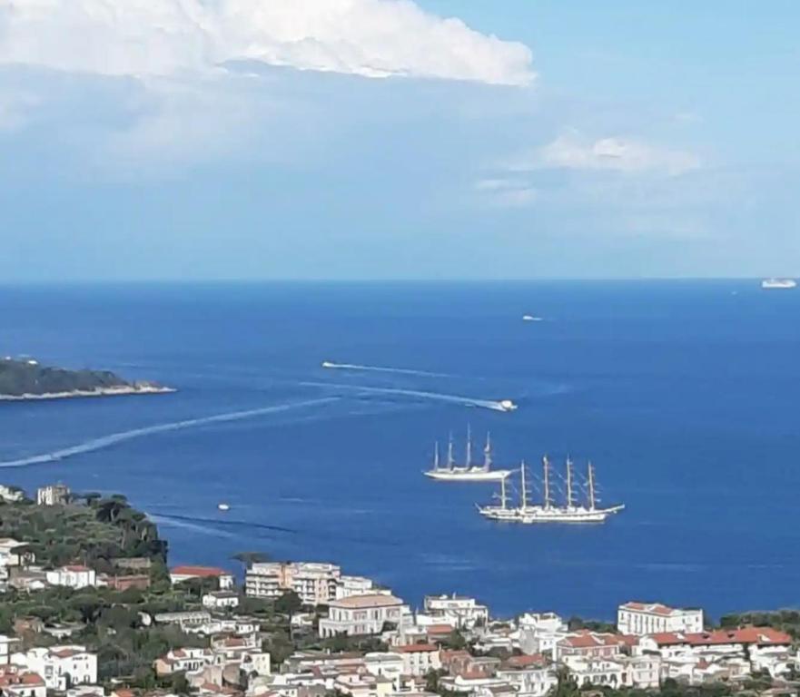 two boats floating in the water near a city at La Culla di Minerva in Meta