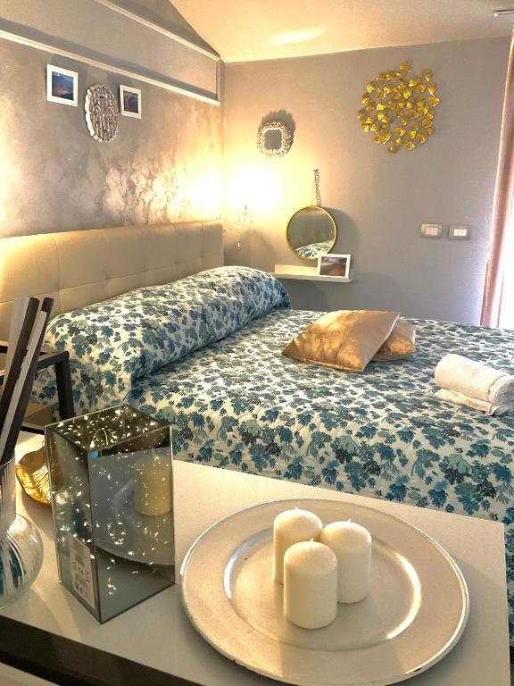 a room with a bed with two candles on a table at Mizzicahome SoleMare Catania in Catania