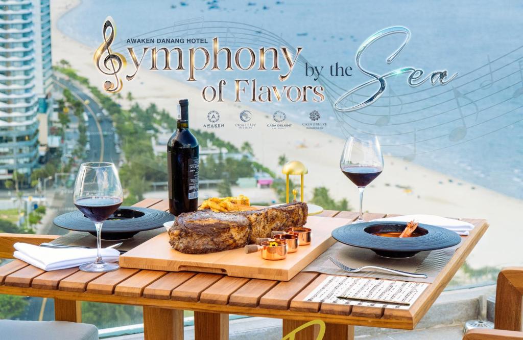 a table with food and wine and a sign that reads symphony of flavors at Awaken Da Nang Hotel in Danang
