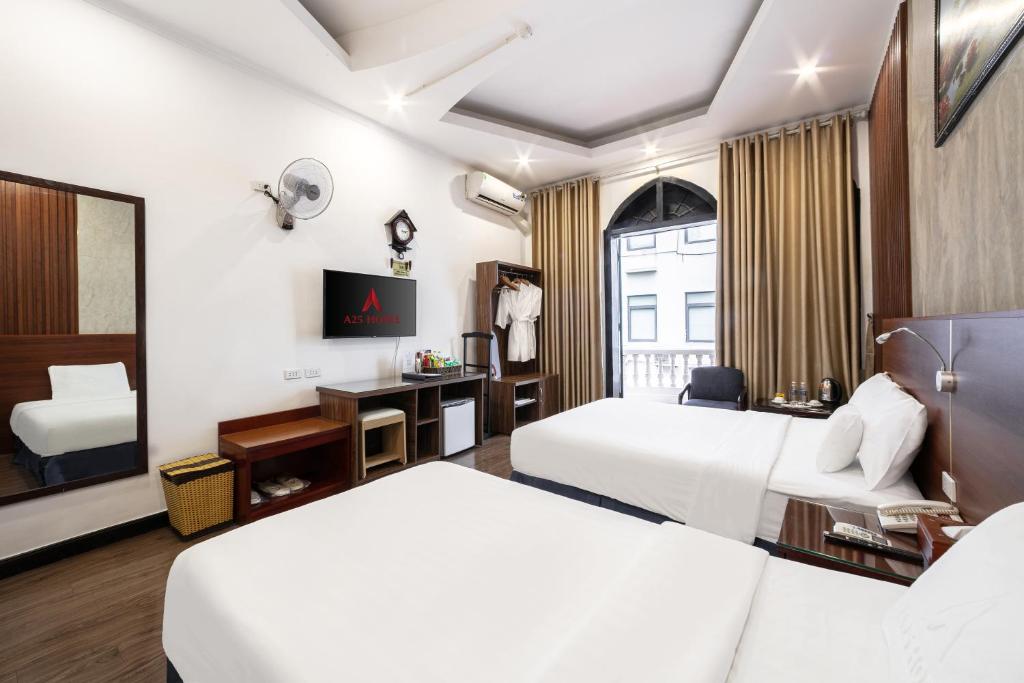 a hotel room with two beds and a tv at A25 Hotel - 12 Liên Trì in Hanoi