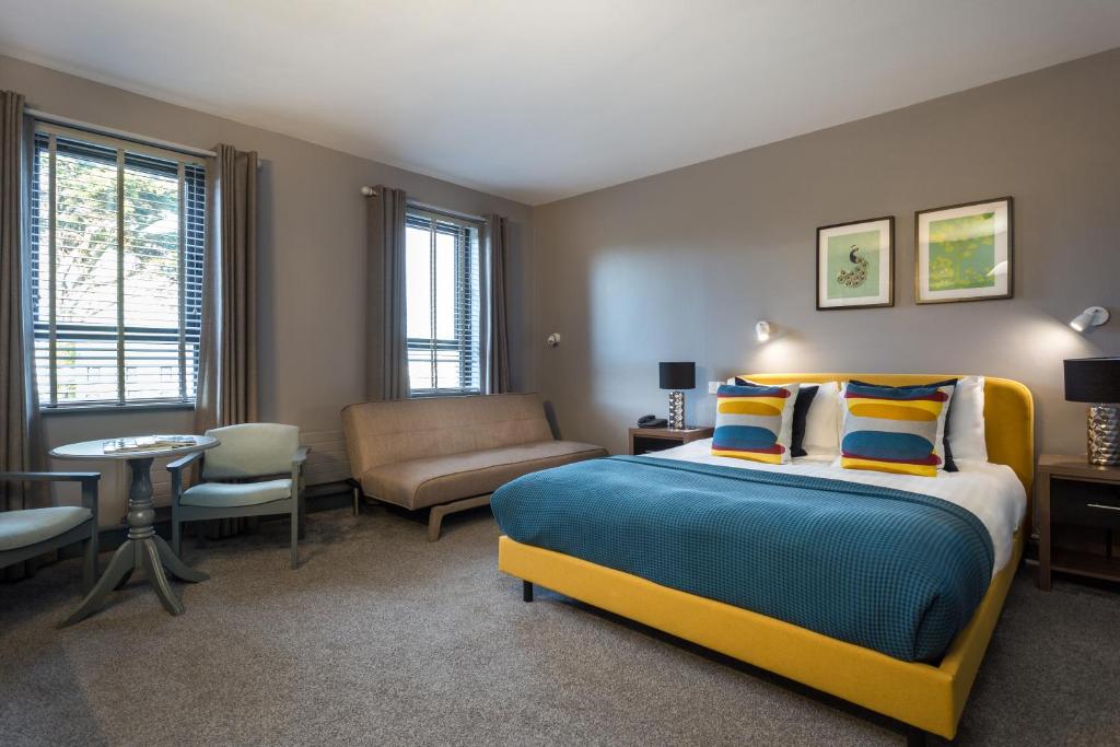una camera con letto, divano e sedia di Coast Rosslare Strand a Rosslare