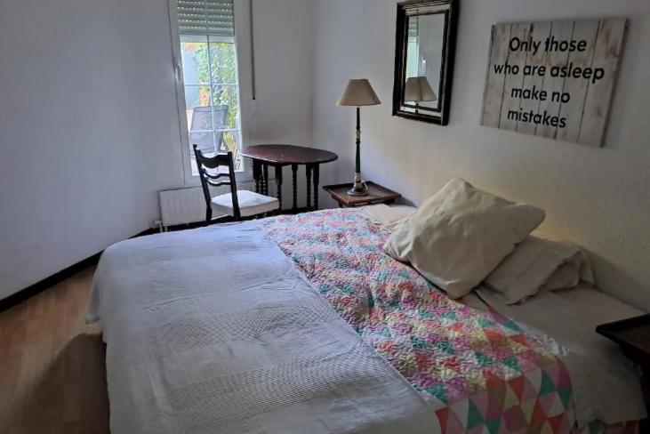 a bedroom with a bed and a table and a chair at Casa Cerca del Aeropuerto y del Jarama in Santo Domingo