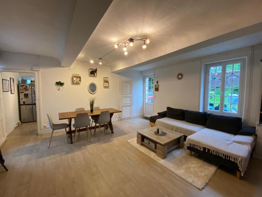 un salon avec un canapé et une table dans l'établissement Maison familiale avec piscine, proche des plages du débarquement, à Ryes