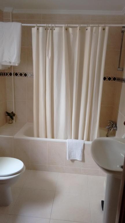 Un baño con cortina de ducha y lavabo. en Casa Rural Aristondo Agroturismo, en San Sebastián