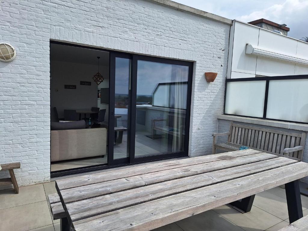 a wooden bench sitting in front of a building at zonnig vernieuwd penthouse dicht bij het strand in Knokke-Heist