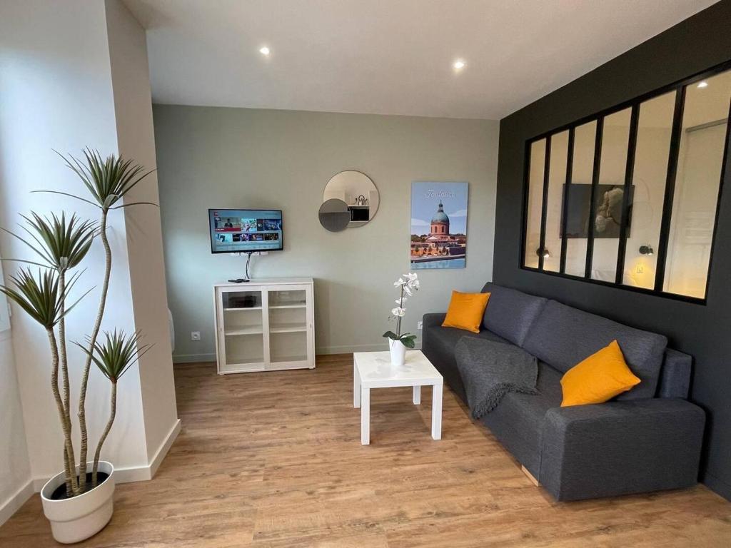 un salon avec un canapé et une télévision dans l'établissement Climatisation, Ascenseur R5 Sublime T2 tout neuf, à Toulouse