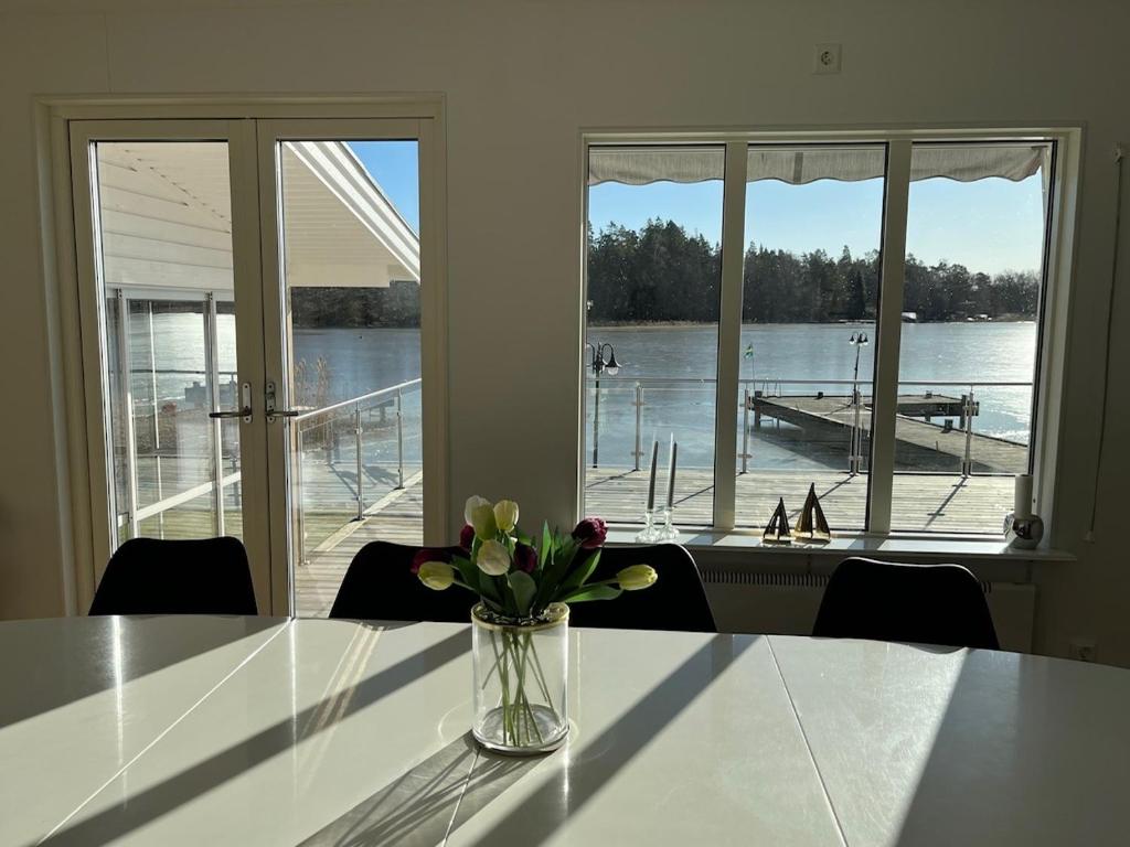 a vase of flowers on a table with a view of a dock at Villa Solsa in Nynäshamn