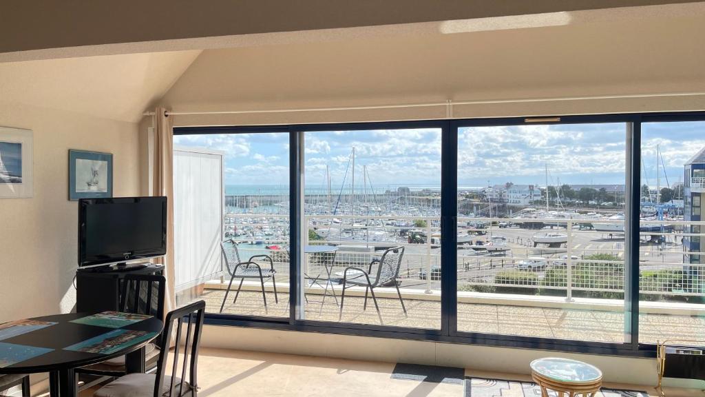 - un salon doté d'une grande fenêtre offrant une vue sur la ville dans l'établissement Plaisance, à Granville