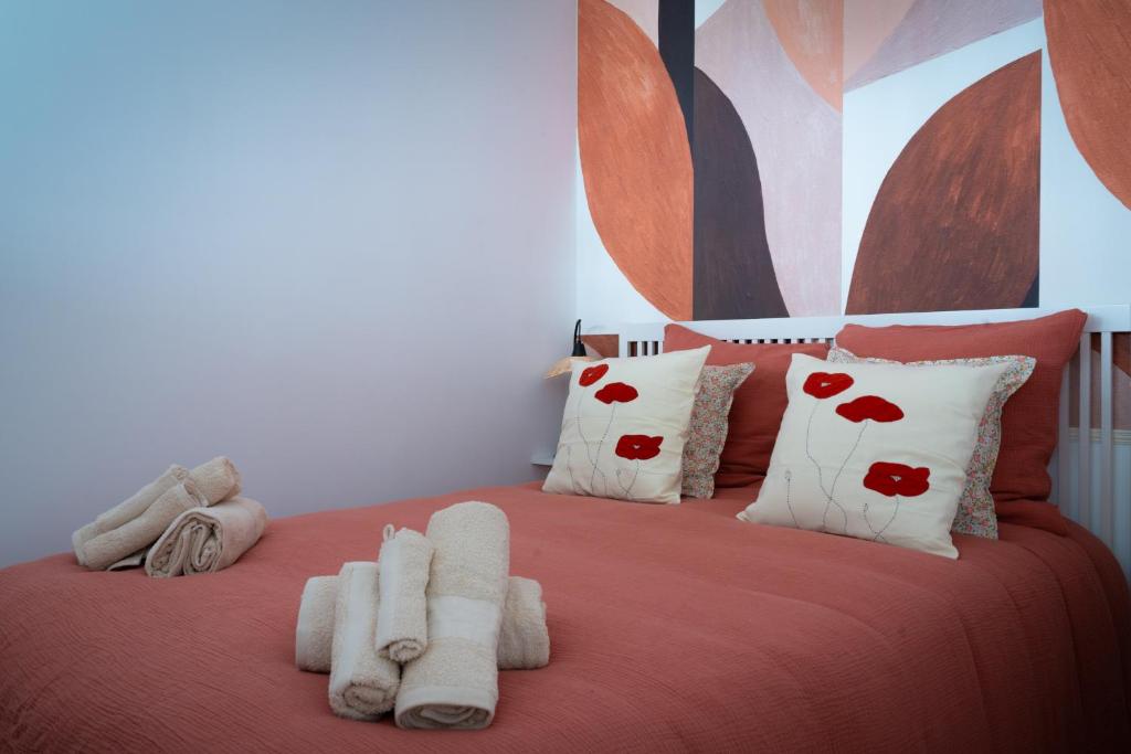 - une chambre avec un lit doté de draps et d'oreillers rouges dans l'établissement Le coquet à 20min de Paris et de l'aéroport d'Orly, à Juvisy-sur-Orge