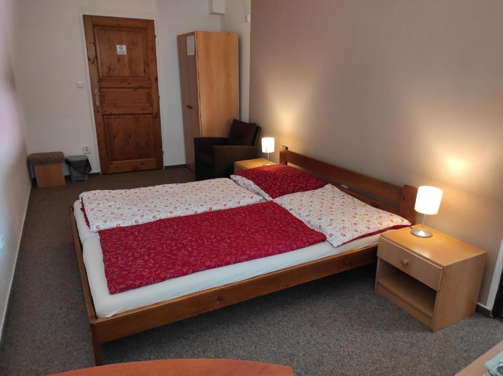a bedroom with a large bed with a red comforter at Penzion a restaurace U Knoppa in Opava