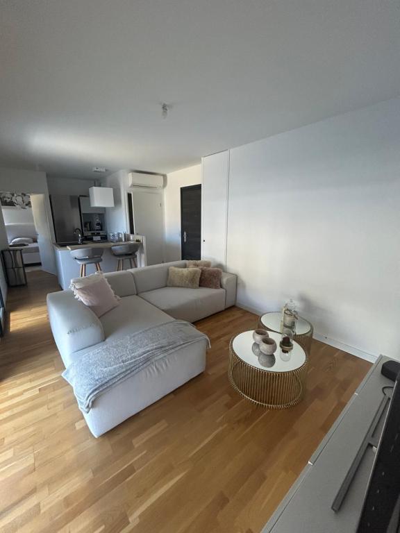 un salon avec un canapé blanc et une table dans l'établissement Appartement T2 très bon standing !, à Ajaccio
