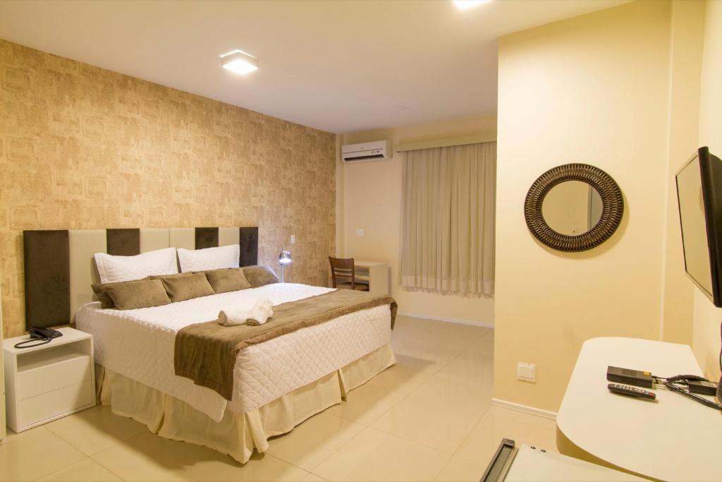 a bedroom with a large bed and a mirror at San Phillip Flat Hotel in Fortaleza