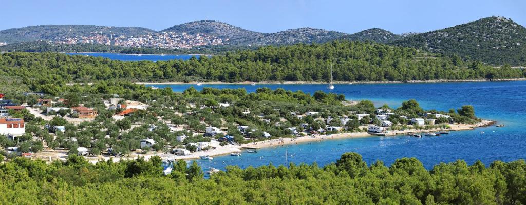 an island in a body of water with boats at Kamp Oaza Lučica in Drage