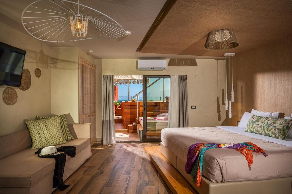 a bedroom with a large bed and a couch at Esperides Resort Crete, The Authentic Experience in Hersonissos