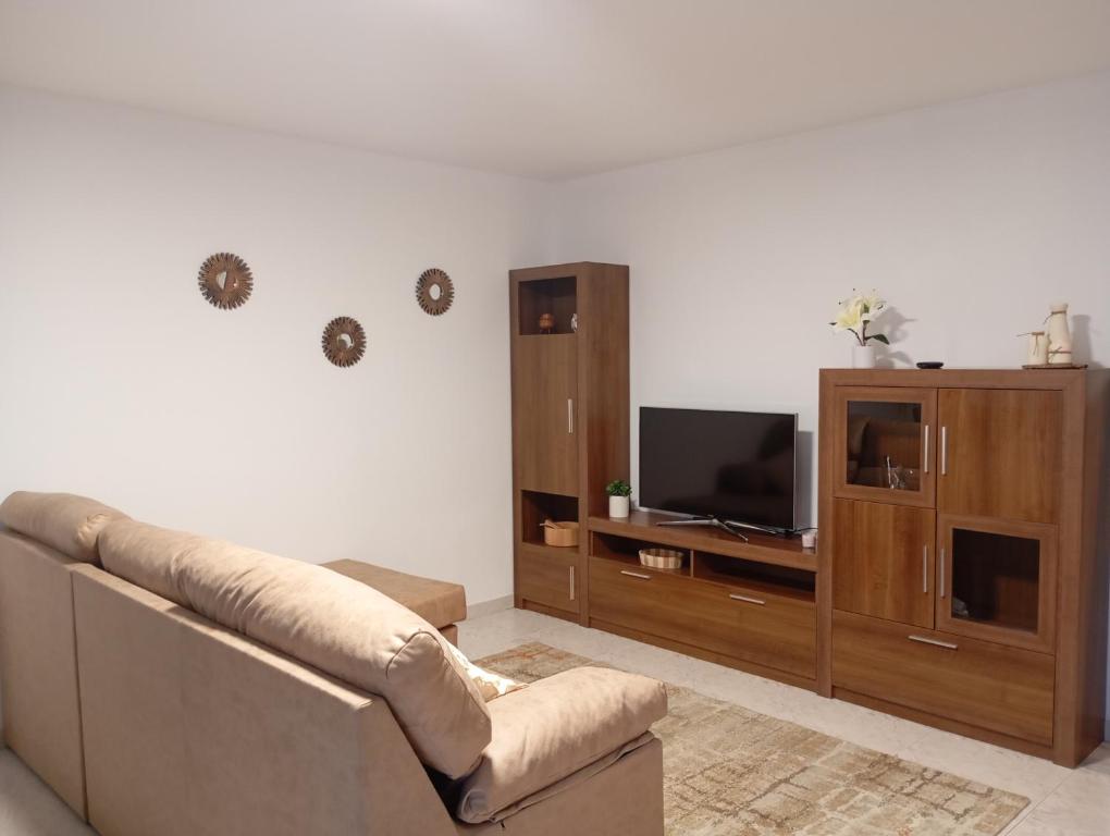 a living room with a couch and a tv at Casa A Brea in Pontevedra