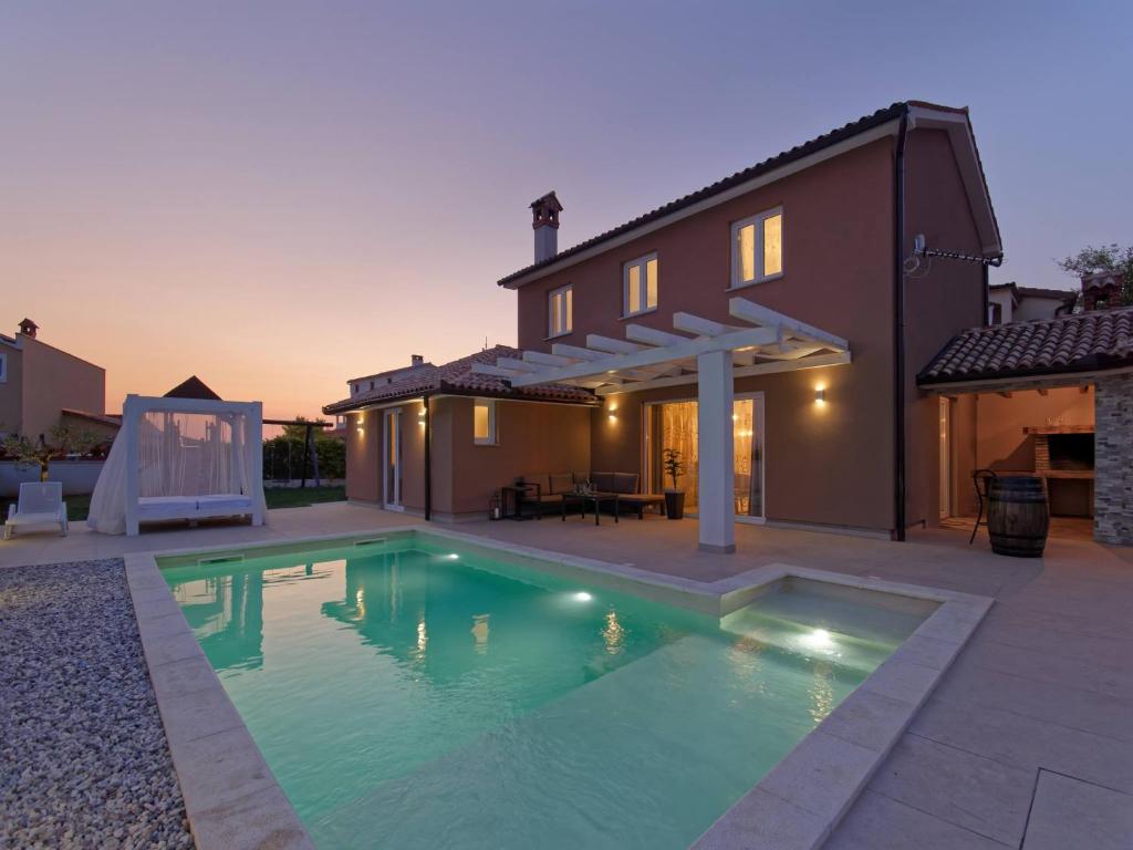 a swimming pool in front of a house at Villa Matthias by Rent Istria in Ližnjan