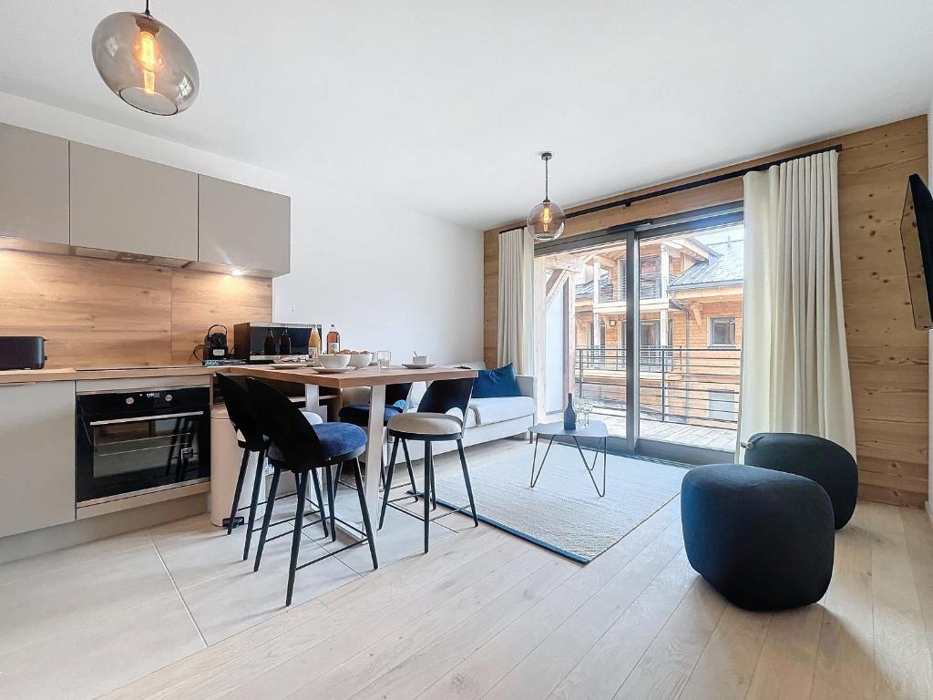 une cuisine avec une table et des chaises dans une pièce dans l'établissement Corylus-appartement-4Pers-Centre Station, aux Gets