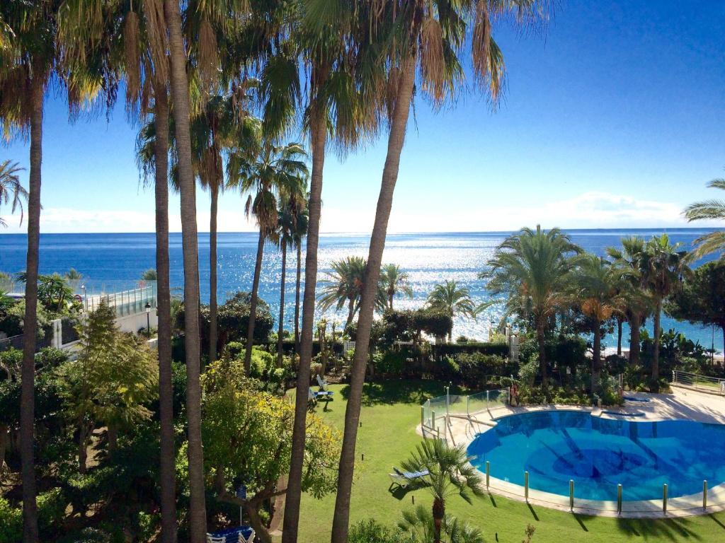 a view of the ocean from a resort with palm trees at GRAN MARBELLA APARTMENTS by Coral Beach in Marbella