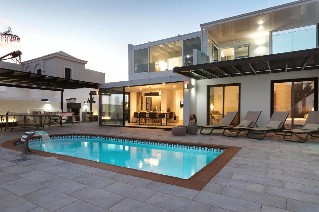 ein Haus mit einem Swimmingpool vor dem Haus in der Unterkunft Villa María in Playa Blanca