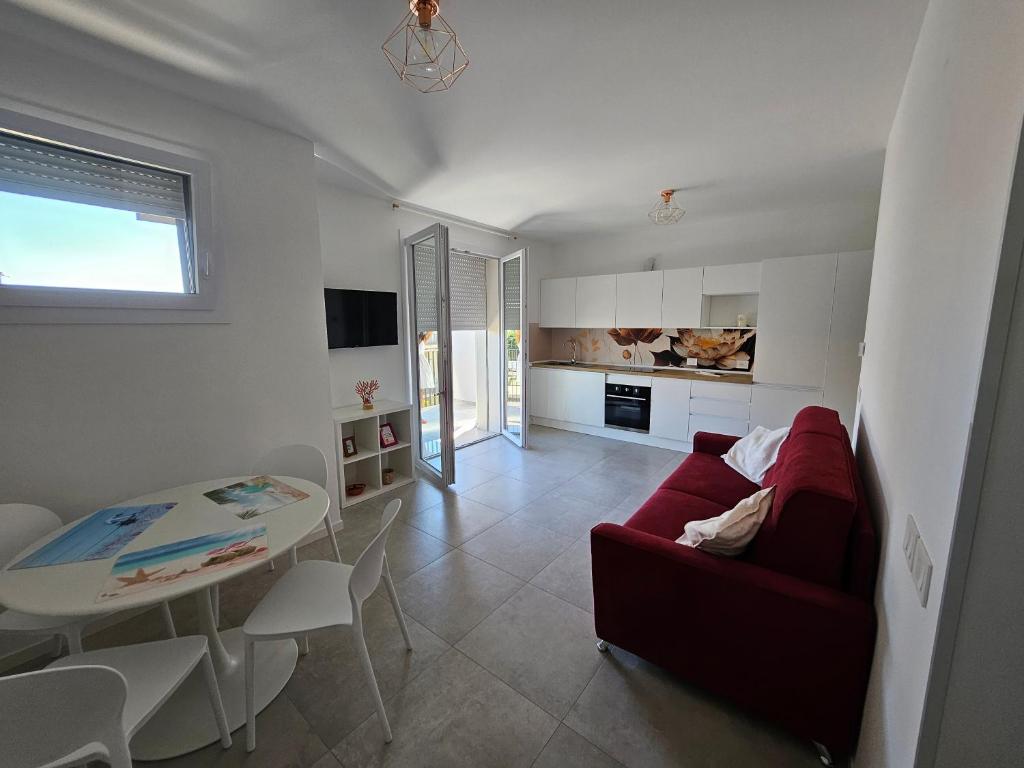 a living room with a red couch and a table at CasaMARina in Misano Adriatico