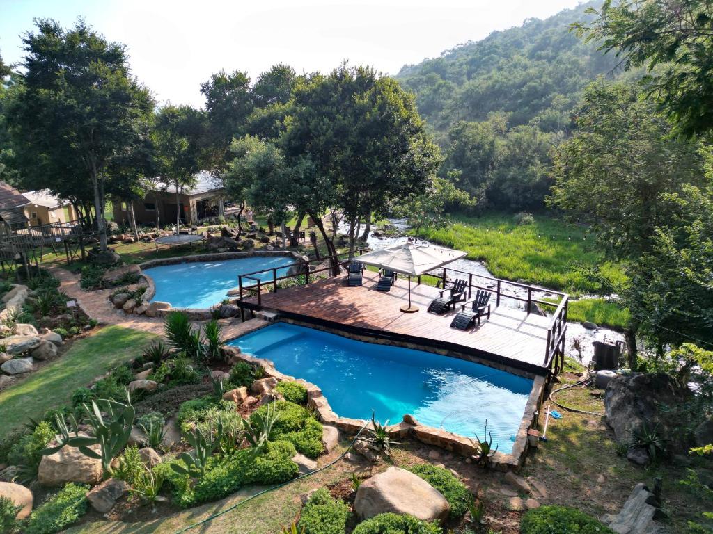 eine Draufsicht auf einen Pool in einem Garten mit einer Terrasse in der Unterkunft Rocky Drift Private Nature Reserve in Waterval Boven