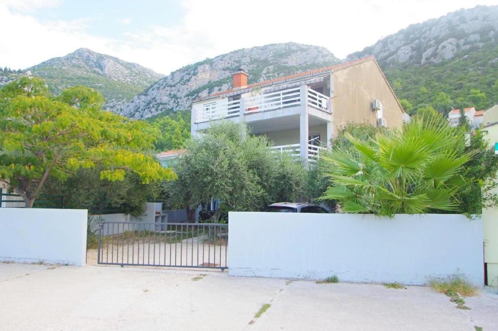 a house with a fence and mountains in the background at Ferienwohnung Am Strand in Klek
