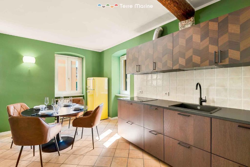 a kitchen with a table and chairs and green walls at La Perpetua, Terre Marine in Riomaggiore